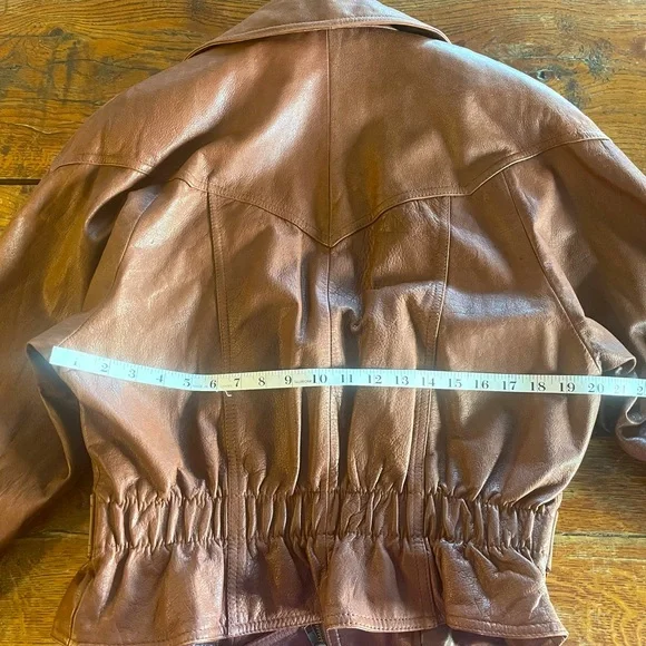 Vintage Brown leather moto jacket with zipper closure and belt detail.